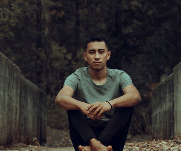 Person sitting peacefully in a meditation pose, looking serene and focused.