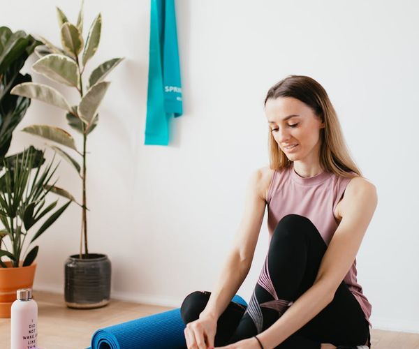 Yoga mat rolled out next to a water bottle and a small towel.